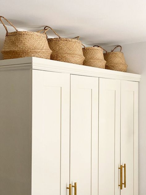 Topping the wardrobes with a row of seagrass baskets helps utilize every square inch of the wall for storage. Above Wardrobe Decor, Wardrobe With Baskets On Top, Decorating Top Of Wardrobe, Wardrobe Top Storage, Baskets On Top Of Wardrobe, On Top Of Wardrobe Storage, Baskets On Wardrobe, Boxes On Top Of Wardrobe, Storage On Top Of Wardrobes