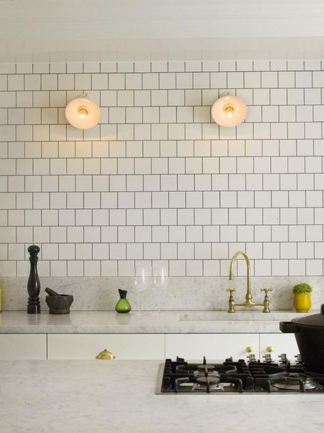 Like: White tile. Dark grout. Brass bridge faucet with gooseneck spout. Brass cabinet hardware. Industrial utility lights. Top Kitchen Trends, White Kitchen Backsplash, White Ceramic Tiles, Herringbone Backsplash, Kitchen Backsplash Designs, Kitchen Splashback, Kitchen Marble, Kitchen Tile, Square Tile