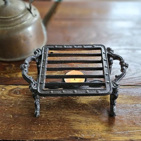 The Cast Iron Pot Warmer Trivet is perfect for adding an old-time touch with tons of practicality. This cast iron trivet is designed to keep teapots and other small pots warm. It features a tea light candle holder to warm tea or pots of milk. Only suitable for tea light candles less than 4cm / 1.6" in size (candle not included). 7.25"L (with handles) x 5" Diam surface x 2.9"H Trivet only. (Copper items not sold.) Heat Keeper Teapot sold separately. Cast Iron Decor Ideas, Diy Cabin Furniture, Cast Iron Decor, Primitive Cottage, Small Pots, Kitchen Necessities, Cast Iron Pot, House Items, Antique Dishes