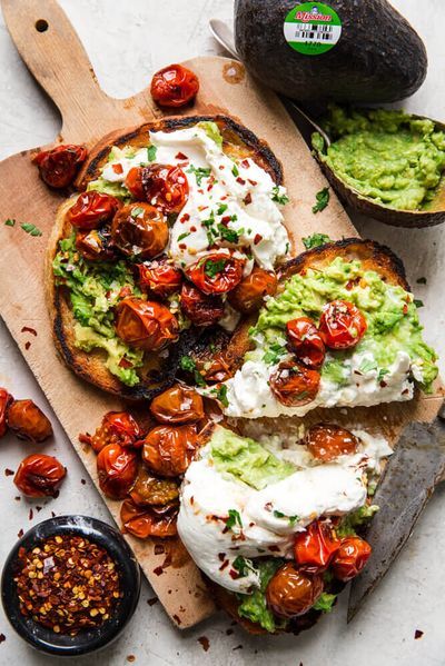 Create this stunning and flavorful gourmet avocado toast that will make breakfast or lunch feel like you are at a 5 start restaurant. Whip up this incredibly beautiful recipe today from The Produce Moms Tomatoes And Burrata, Toast Restaurant, Halloween Headpiece, Avocado Recipes Dinner, Blistered Tomatoes, Toast Recipe Breakfast, Avocado Dishes, Toast Ideas, Avocado Toast Recipe