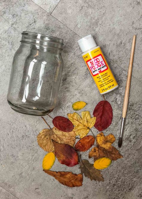 Easy leaf mason jar lanterns nature craft - Growing Family Pressed Flower Jars, Crafts With Fall Leaves, Mason Jar Lanterns Diy, Leaf Lantern Craft, Waldorf Festivals, Recycled Candle Jars, Seasons Craft, Leaf Mason Jar Candle, Fall Mason Jar Crafts