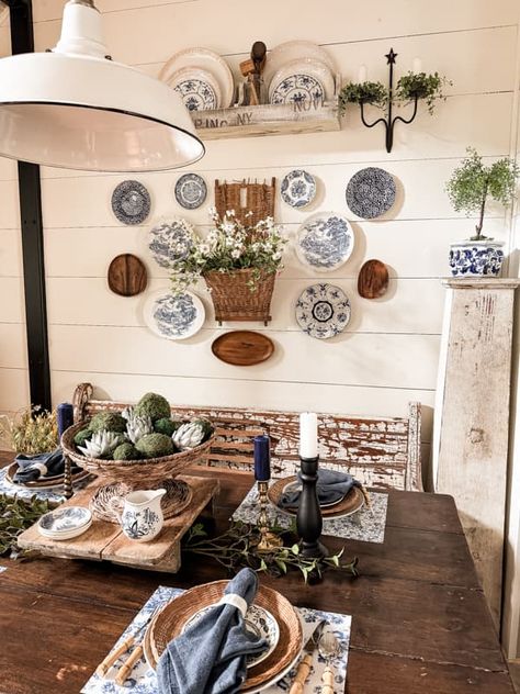 Decorate dining room wall with plate wall decor and vintage basket beside the farmhouse table. Plates And Pictures On Wall, Plates Around Picture On Wall, Decorative Plates On Wall Kitchen, Wall Collage With Baskets, Decor Plates On Wall, Plates In Frames Wall Decor, Plate And Basket Wall, Decorating With Plates On Wall Ideas, Dining Room Vintage Decor