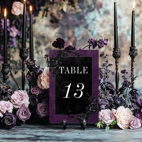 Transport your guests to a world of dark, enchanting elegance with our vintage gothic wedding table number card. The deep, aged royal purple background sets the stage for a striking contrast, as bold white text emerges from intricate black text boxes. The back is adorned with two intertwining vines of black roses, which adds a touch of dramatic allure. Unleash the magic and set the tone for an unforgettable wedding day. This card is part of the Created by Simply Farmhouse Press. Spooky Halloween Wedding Decor, Black Burgundy And Purple Wedding, Lavender Black Wedding, Lavender Sage Black Wedding, Dark Purple And Silver Wedding, Burgundy Purple Green Wedding, Black And Purple Goth Wedding, Black And Purple Table Decor, Purple And Black Flower Arrangements