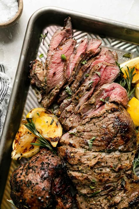 This Butterflied Grilled Leg of Lamb is the ultimate summer feast! Slather boneless / butterflied leg of lamb in a Mediterranean-inspired marinade made of lemon, garlic, & herbs. Cook on the grill until perfectly charred yet super juicy & meltingly tender. Serve with pita & a mezze platter or a few simple sides – grilling butterflied leg of lamb is SO simple & makes the best backyard Sunday supper with family & friends! #grilledlamb #grilledlambleg #grilledlambrecipes #legoflamb #... Leg Of Lamb Marinade, Grilled Lamb Recipes, Grilled Leg Of Lamb, Summer Feast, Butterflied Leg Of Lamb, Lamb Roast Recipe, Lamb Marinade, Mezze Platter, Simple Sides