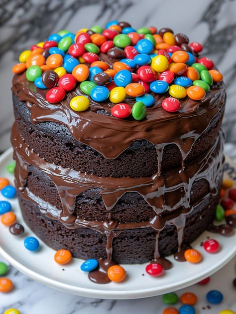 Chocolate M&M Celebration Cake 🌟 With layers of moist chocolate cake, rich chocolate frosting, and colorful M&M candies, every bite is a celebration of sweetness and joy!  🌟 𝗜𝗻𝗴𝗿𝗲𝗱𝗶𝗲𝗻𝘁𝘀 🌟 For the Cake: 🍬 2 cups all-purpose flour 🍬 2 1/2 cups granulated sugar 🍫 3/4 cup unsweetened cocoa powder 🥄 2 teaspoons baking powder 🥄 1 1/2 teaspoons baking soda 🧂 1 teaspoon salt ☕ 1 teaspoon espresso powder 🥛 1 cup buttermilk 🛢️ 1/2 cup vegetable oil 🥚 2 large eggs Chocolate M&m Cake, Cupcake Recipes Uk, Cake With Layers, M&m Cake, Chocolate Desserts Cake, M&m's Chocolate, Unsweetened Cocoa Powder, Cupcake Recipes Chocolate, Decadent Chocolate Cake