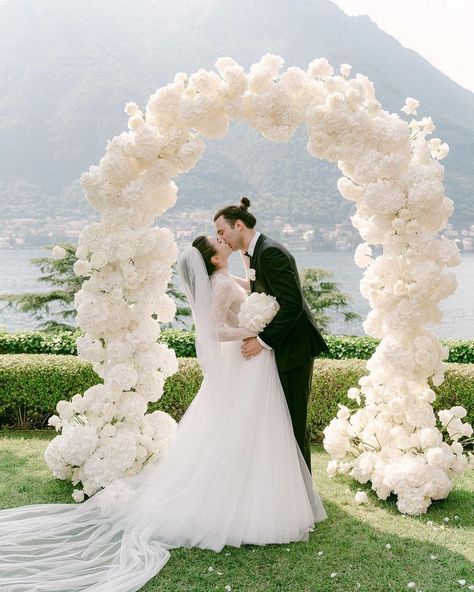 This timeless Italian affair was one for the books! 🇮🇹What's more romantic than a kiss beneath a floral arch overlooking gorgeous… | Instagram Full Flower Arch Wedding, White Floral Wedding Arch, White Floral Arch, Flower Arch Elegant Waterview, All White Floral Arch, White Grounded Floral Arch, Big White Flowers, White Wedding Arch, Modern Wedding Theme