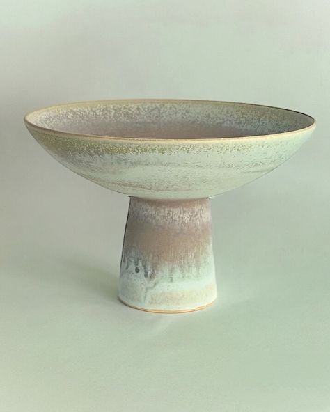 Envision a sunlit table draped in a soft linen cloth, bathed in natural light that dances across its surface. Elegant dishware is thoughtfully arranged, complemented by crystal glasses that catch the light, sparkling with promise, while tall, slender candles stand poised to add a warm, inviting glow. At the heart of this setting, three ceramic pedestal bowls take their place. One holds a vibrant array of seasonal fruits, their colors popping against the muted tones of the ceramics. Another c... Ceramic Pedestal Bowl, Elegant Dishware, Pedestal Bowls, Candles Stand, Ceramic Pedestal, Seasonal Fruits, Pedestal Bowl, Crystal Glasses, Linen Cloth