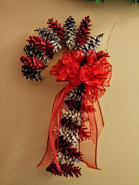 The wreath form and ribbon were from Dollar Tree and the paint was from Walmart. The pine cones are from my yard! Complete for under 5 dollars!! Red Pine Cones, Pine Cone Candy Cane, Pine Cone Candy Cane Wreath, Pinecone Candy Cane, Pinecone Candy Cane Wreath, Pinecone Wreath Christmas, Pine Cone Wreath Ideas, Large Pine Cone Crafts Ideas, Christmas Decorations Pinecones