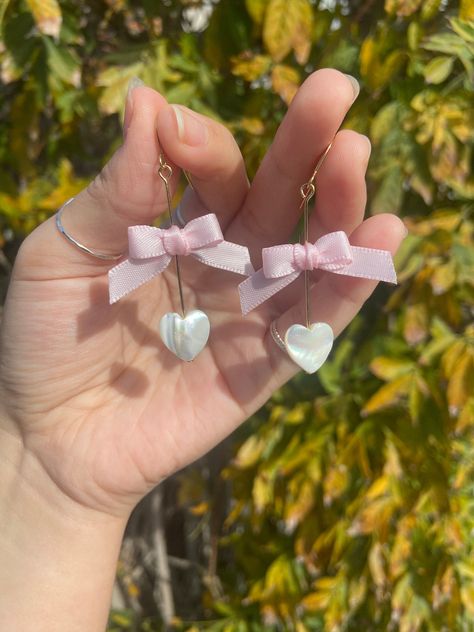 Rose Quartz Heart Bow Earrings | Healing Crystal Earrings | Symbolizes Universal Love | Relieve Stress Pearl Heart Bow Earrings | Dangle Earrings | Elegant Jewelry | Handmade Earrings | Wire Wrapped Earrings | Gift for Her Both Heart Earrings are finished with handmade bow made of ribbon | These are available in both gold and silver and they are the perfect gift for Valentines Day! This design takes longer, so please be aware of that for shipping rates! Earrings With Ribbon, Dainty Heart-shaped Earrings For Parties, Feminine Earrings For Valentine's Day Party, Dainty Heart Earrings For Party, White Feminine Heart Earrings For Valentine's Day, Feminine White Heart Earrings For Valentine's Day, Valentine's Day Rose Gold Heart Earrings For Party, Feminine Dangle Heart Earrings For Valentine's Day, Feminine Heart Charm Earrings For Gift