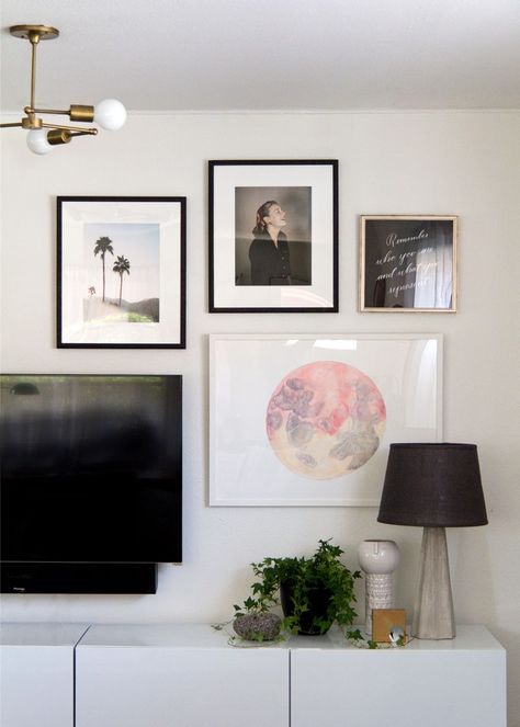 When it comes to the question of how to hang a gallery wall, there’s a ton of decisions to make. First you have to select the right mix of art. You have to choose the frames. Then you’ve got to design the ideal arrangement for your space. Oh, and don’t even get me started on … Tv Wall Asymmetrical, Tv And Art Wall, Picture Wall Ideas Above Tv, Gallery Wall Mounted Tv, Asymmetrical Gallery Wall, Asymmetrical Tv Wall, Living Room Decor Around Tv, Bedroom Tv Wall Decor, Tv Art Wall