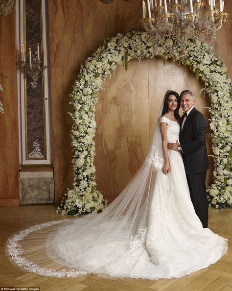 A classic: The French lace gown was embroidered with diamante and pearls and featured a circular train, while the wide neckline scooped just off her shoulders Amal Clooney Wedding Dress, Amal Clooney Wedding, George Clooney Wedding, Amal Alamuddin, Celebrity Bride, Iconic Weddings, Celebrity Wedding Dresses, Poppy Delevingne, Most Beautiful Wedding Dresses