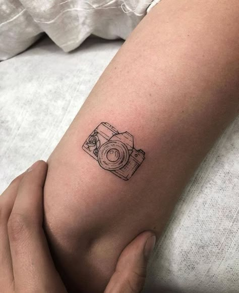 The 90 Most Popular Symbols For Travel Tattoos | Unique & Cute Travel Tattoo Ideas Arm Tattoo Photography, Cute Camera Tattoo Ideas, Small Tattoos Photography, Small Tattoos Camera, Vintage Camera Tattoo Design, Photo Camera Tattoo, Camera Outline Tattoo, Mini Camera Tattoo, Camera Minimalist Tattoo