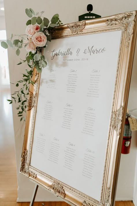 Gold framed seating chart decorated with light pink florals Formal Seating Chart Wedding, Wedding Seating Chart Frames, Seating Chart Floral Arrangement, Romantic Wedding Seating Chart, Wedding Table Assignment Ideas Diy, Seating Chart Wedding Elegant, Wedding Table Assignment Ideas Reception Seating, Wedding Seating Chart Simple, Seating Wedding Chart