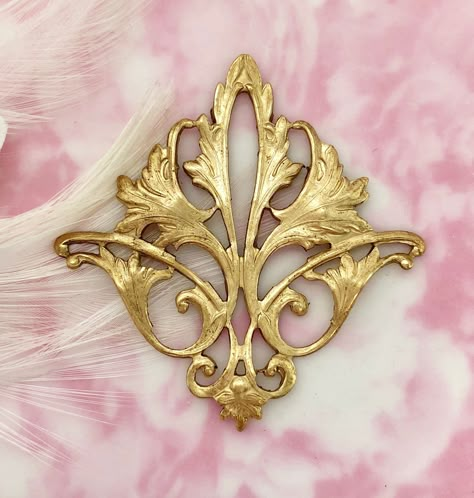 "Style: Filigree acanthus Leaf Stamping Finish: Raw Brass Quantity: 1 Piece Origin: Made in the USA approximately Size: Height: 2\" Width: 2\" Gold Tone Item Does Not Have a Loop or Hole. Item Has a Hollow Back. If you do not see the quantity that you need, please contact us. We may be able to accommodate your custom request. ----ღஐ SHIPPING ஐღ--- Shipping may be combined on multiple items purchased in one payment. If payments are made separately, shipping cannot be combined. For declaration amo Leaf Stamping, Stamping Jewelry, Flourish Design, Brass Filigree, Tattoo Lettering Fonts, Lace Mask, Acanthus Leaf, Silver Lockets, Oxidised Jewellery