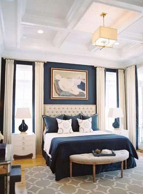 a refined bedroom with a navy accent wall, a creamy upholstered bed, navy and white bedding, creamy curtains and white nightstands Navy And White Bedding, Navy Accent Wall, Grey Upholstered Bed, Stained Dresser, White Nightstands, Navy Accent Walls, Navy Furniture, Light Gray Bedroom, Cool Chandeliers