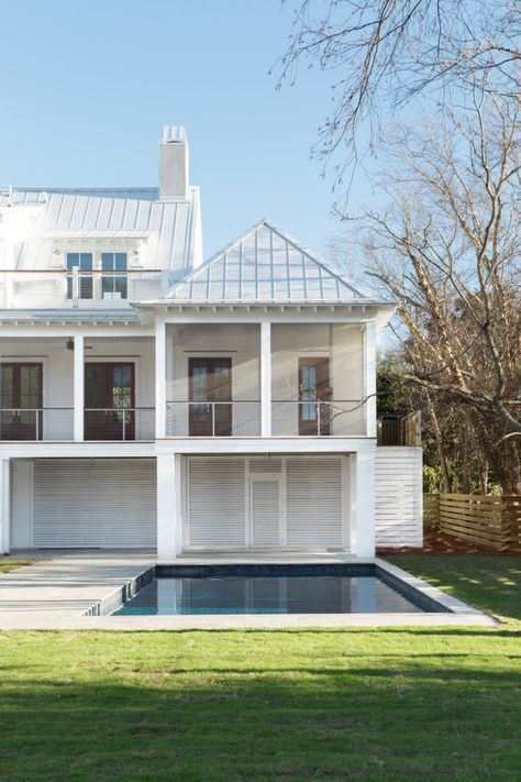 Coastal home with rafters, a white exterior and blue Malibu awnings White House Metal Roof, White Beach House Exterior Coastal, White Coastal Homes Exterior, Metal Roof Coastal House, White Metal Roof, Metal Roof Beach House, Beach House Metal Roof, White Beach House Exterior, Modern Coastal Fascade