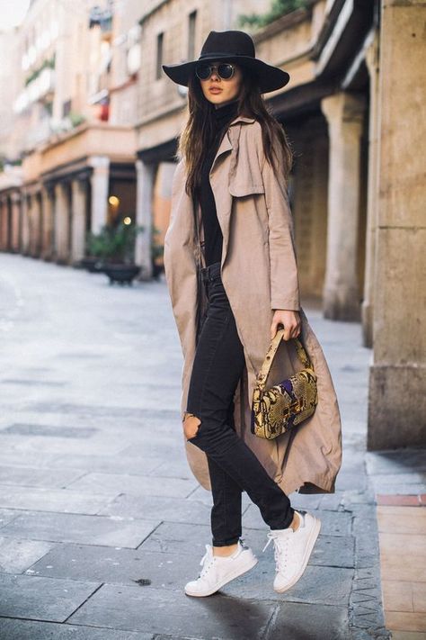 Chica usando sombrero de color negro con outfit de tenis blancos, jeans y blusa negra, junto una gabardina camel Best Ripped Jeans, Trenchcoat Outfit, Ripped Jeans Outfit, Europe Outfits, Streetwear Mode, Outfit Shopping, Outfit Jeans, Urban Street Style, Outfits With Hats