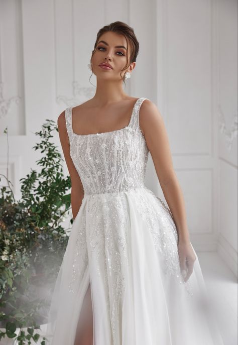 This A-line wedding dress is a beautiful and sophisticated choice for any bride. The square neckline and mid-back design are classic and elegant, while the sleeveless cut adds a touch of modernity. The flowing skirt creates a romantic and timeless look, while the simple and minimalist design allows for the bride to customize her look with accessories. Made with high-quality fabrics, this dress is sure to make any bride feel confident and radiant on her special day. Aline Tank Top Wedding Dress, Straight Dress Wedding, Straight A Line Wedding Dress, Simple Sparkling Wedding Dress, Straight Neck Line Wedding Dress, Aline Wedding Dress Square Neckline, Squared Neckline Wedding Dresses, Sparkly Aline Wedding Dress, Straight Line Wedding Dress