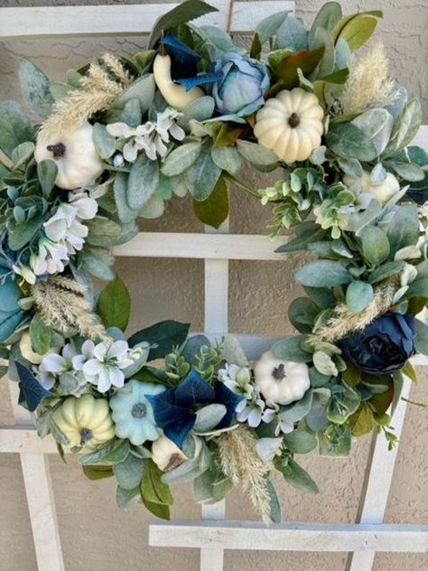 If you're looking for a blue fall pumpkin wreath with a coastal vibe, here it is!  We capture so many different textures to make the most eye pleasing wreath!!  A natural grapevine wreath base is embellished with soft lambs ear and eucalyptus greenery, and topped with peonies in different shades of blue, delicate white cherry blossoms and eucalyptus leaves in the richest shade of blue.  Top it off with blue and cream pumpkins and pampas grass!  There is so much dimension in this wreath, making it a showstopper for your front door, or the perfect addition to the wall above your fireplace mantel or a beautiful mirror in your home.  Only 1 Available! 22 inch diameter For indoor or covered outdoor use Lifelike greenery with artificial and natural embellishments Blue And White Pumpkin Decor, Blue Eucalyptus Wreath, Blue Halloween Decorations, Fall Decor With Blue Accents, Fall Decor With Blue, Blue Pumpkin Decor, Thanksgiving Front Door, White Pumpkin Decor, Holidays Decorations