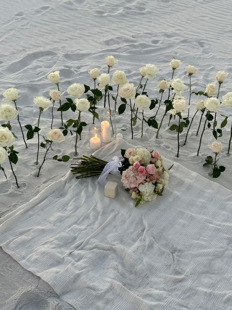 Roses In Sand Proposal, Proposal At The Beach Ideas, Cute Proposal Set Up, Beach Proposal White Roses, Beach Engagement Setup Ideas, Sunset Beach Proposal Ideas, Proposal Ideas White Roses, Proposal Ideas Flower Field, Intimate Beach Proposal