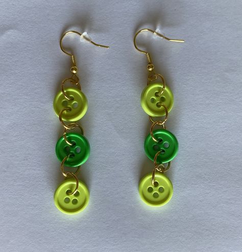 A pair of adorable button earrings! Each earring features two (2) light green buttons and one (1) dark green button that creates a color combination that's perfect for springtime! This pair is a great accessory for a crafter in your life, whether that would be you or someone you know! The earrings use plastic buttons that are connected via jump rings. They have a drop length of approximately 2.75 inches. Each button is approximately 3/8 of an inch in diameter. The earrings use fish hook findings Button Ideas, Easy Handmade, Ear Ring, Handmade Jewelry Tutorials, Button Jewelry, Button Earrings, Black Thread, Button Crafts, Green Button