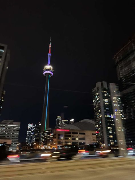 Capturing the mesmerizing beauty of the CN Tower illuminated against the night sky, surrounded by a bustling cityscape with streaks of passing cars. The tower stands tall as a beacon of architectural wonder, while the vibrant lights and dynamic movement of traffic below paint a stunning scene of urban energy and nighttime allure. 🌃🚗 #CNTower #CityLights #UrbanNights Toronto Canada At Night, Cn Tower Painting, Toronto Downtown Night, Canada Cn Tower, Cn Tower At Night, Tower Stand, Dynamic Movement, Mesmerizing Beauty, The Night Sky