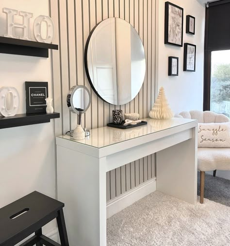 Put a modern spin on an old-world design with a contemporary dressing table in front of evenly spaced vertical wall panels. A color palette featuring black, white, and gray uses contrast to form a super-modern look. A boucle chair showcases the shape of a seashell while accessorizing one corner. Panelling Dressing Room, Dressing Room Panelling, Modern Dressing Table Designs, Modern Dressing Table, White Dressing Tables, Dressing Room Decor, Luxury Room Bedroom, Dressing Table Design, Bedroom Dressing Table