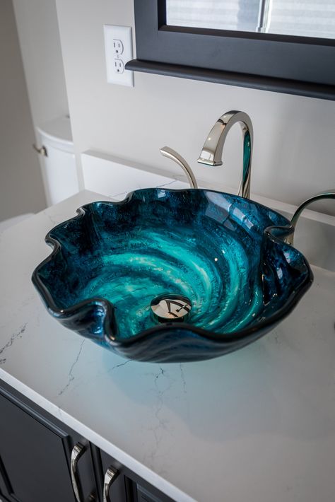 The Eden Bath Caribbean Wave above counter glass vessel sink is made of high quality tempered glass in a free form shape. The free form shape is highlighted with multiple shades of blue swirling like Caribbean Waves. The finish is hand painted by skilled artisans. Each sink has slight color variations with the different shades of blue blending into each other, no two will be identical. This sink is sure to be a focal point of your bathroom. Eden Bath specializes in unique glass vessel sinks that Sea Themed Bathroom, Sea Bathroom, Ocean Bathroom, Bathroom Sink Bowls, Bathroom Recessed Lighting, Unique Sinks, Glass Vessel Sinks, Glass Sink, The Eden