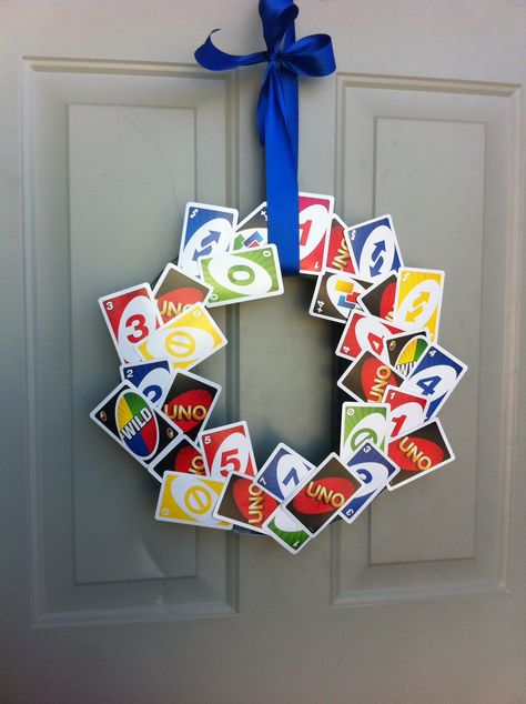 Awesome UNO Wreath on the front door. Made by Megan Gillies and her mother. Just need UNO cards, hot glue gun, ribbon, a styrofoam wreath from Hobby Lobby, and creativity! Uno Card Decorations, Game Night Wreath, Uno Card Crafts, Uno Card Game Birthday Party Theme, Uno Decorations Ideas, Uno Decorations, Uno First Birthday Party, Board Game Theme Party, Uno Birthday Party Theme