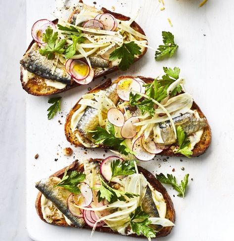 Think of this as a tuna sandwich with an elegant, adult twist. First, you’ll make a lemony garlic mayo to spread on toasted multigrain bread. You’ll nestle sardine fillets into the schmear, and pile a fresh fennel-radish salad on top. If you want a more filling meal, add a white bean salad or sliced summer tomatoes sprinkled with flaky sea salt. Sardine Toast, Sardine Recipes, Canned Seafood, Tinned Fish, Mayo Recipe, Multigrain Bread, Garlic Mayo, Pita Pockets, Radish Salad