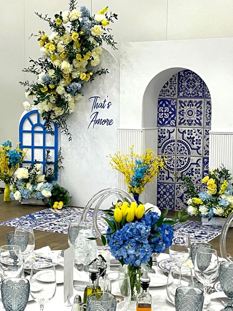 Amalfi themed bridal shower decorations with blue window and white, blue and yellow flowers Bridal Shower Almafi Coast, Italy Lemons Amalfi Coast, Bridal Shower Positano Theme, Amalfi Coast Italy Theme Party, Italy Wedding Shower Theme, Positano Italy Bridal Shower Theme, Amalfi Coast Inspired Home Decor, Amalfi Coast Wedding Dress, Amalfi Coast Centerpiece