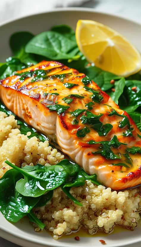 Grilled Salmon with Quinoa and Spinach  Ingredients: - 150g salmon fillet - 1/2 cup quinoa - 1 cup fresh spinach - 1 tbsp olive oil - 1 lemon - Salt and pepper to taste - Fresh parsley for garnish  Instructions: 1. Rinse quinoa under cold water. Cook it in 1 cup of water until water is absorbed and quinoa is fluffy. 2. Preheat grill to medium-high. Brush salmon with olive oil, season with salt and pepper. Grill for 4-6 minutes per side. 3. Sauté spinach in a pan with a little olive oil until wilted. 4. Serve salmon over quinoa, topped with sautéed spinach. Squeeze lemon juice on top. 5. Garnish with parsley.  This dish is rich in omega-3 fatty acids, antioxidants, and protein, promoting heart health and energy. Antioxidant Rich Meals, Fish Based Meals, Clean Eating Pescatarian Recipes, High Protein Salmon Dinner, Fatty Fish Recipes, High Protein Seafood, Pescatarian Diet For Beginners, Sauté Spinach, Salmon With Quinoa