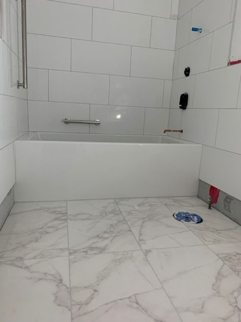 Bathroom renovation in progress Wall tile is Happy Floors style Alaska color White Glossy 12 x 24 Floor tile is Happy Floors style Crystal color White Glossy 15 x 30  We love the floor tile!  It has the look of carrara marble without the price tag and the maintenance. Bathroom White Floor, Shower Wall Tile, White Tub, Bathtub Walls, Tub Tile, White Shower, Bathroom Reno, White Floors, Bathroom Renos