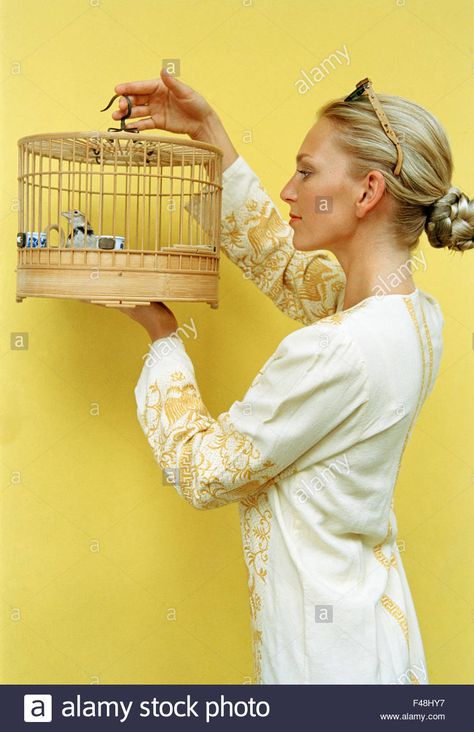 Woman holding a birdcage, Singapore. Stock Photo Woman Holding Bird, Cage Reference, Stock Photos Woman, Body Inspiration, Bird Cage, Bird Feathers, Full Body, Art Reference, Singapore