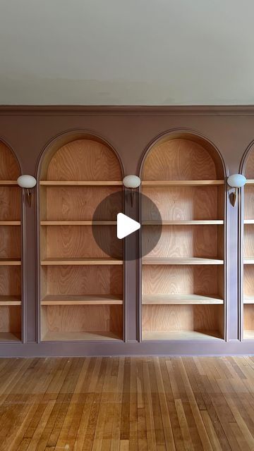 Jourdan Fairchild on Instagram: "Meet our latest—and dare I say greatest—design project to date: a wall of custom arched bookshelves with stained wood interiors and vintage Italian lighting.✨  What started from my sketch on paper in May of last year, my husband Andrew drew directly on the wall with a pencil and then weekend by weekend over 10(!) months built into the grandest focal point in our living room. And he really, truly outdid himself with the level of detail at every seam. I’m honestly blown away by his master-level craftsmanship.   They’re unlike anything I’ve seen elsewhere, make the ceilings feel even higher, and just *feel* right for us and this old home. They’ll certainly make us love where we live a bit more.💕" Antique Built In Bookcase, Built In Shelves Library Room, Bookshelves With Arches, Vintage Wall Bookshelf, Custom Bookcases Built Ins, Arched Shelf Built In, Arched Built In Bookcase, Arch Bookshelves, Arched Bookcase Built In