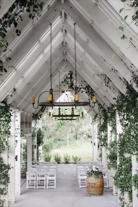 Small wedding venue in a chapel-like open air area with white beams & roof, rustic candle chandeliers and white seating on concrete floor. Wedding Venues Nsw, Australian Wedding Venues, Alternative Wedding Venues, Small Wedding Venue Ideas Indoor, Small Wedding Venues Indoor, Small House Wedding, Small Event Venue Design, Small Venue Space, Simple Wedding Venues