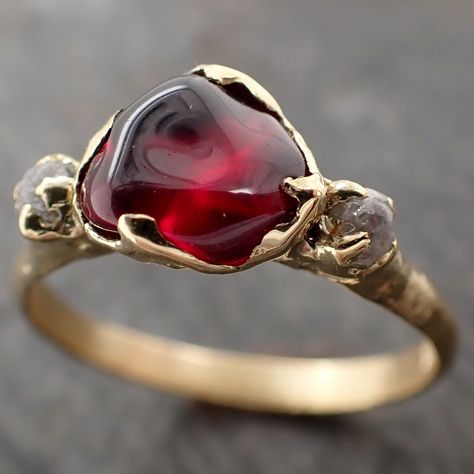 Raw rough color change Garnet with raw conflict-free diamonds on each side. I hand carved this ring in wax and cast it in recycled solid Yellow 18k gold using the lost wax casting process. This one of a kind raw gemstone ring is a size 7 it can be resized up or down. The Garnet measures about 6.5mm x 7.5mm. The rough diamonds are about 2mm. Throughout all time and history in every tribe and culture all around the world crystals, minerals and gemstones have used for healing, luck, divination, ado Raw Ruby Ring, Engagement Rings Raw Stone, Garnet Ring, Raw Stone Engagement Rings, Garnet Wedding Rings, 18k Gold Engagement Ring, Garnet Wedding, Garnet And Diamond Ring, Big Stone Ring