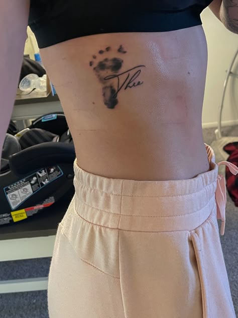 Mom Tattoo Placement, Foot Print Tattoo Baby, Baby Feet Tattoos For Moms, Baby Name Tattoos For Dads, Baby Footprint Tattoo Ideas For Mom, Tattoos For Women With Kids, New Baby Tattoo Ideas, Tattoo Ideas Children, Baby Foot Print Tattoo