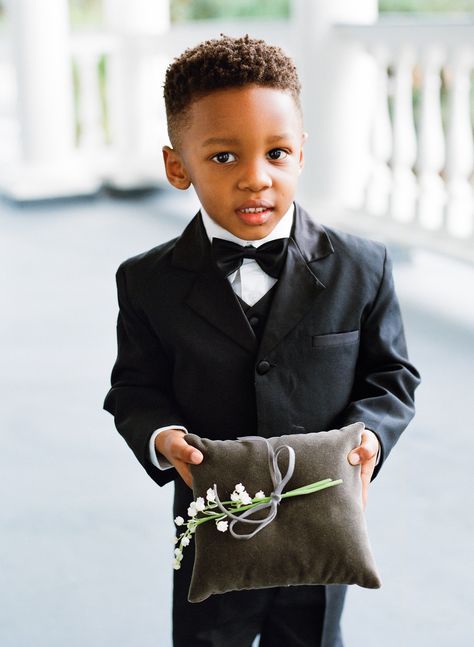 The ring bearer carried a velvet ring pillow with lily of the valley down the aisle. Featured on Martha Stewart Weddings. Ring Bearer Outfit Black, Black Ring Bearer, Grooms Men, Fiji Wedding, Gold Wrap Ring, Bridal Art, College Roommate, Rose Gold Engagement Ring Vintage, Bearer Outfit