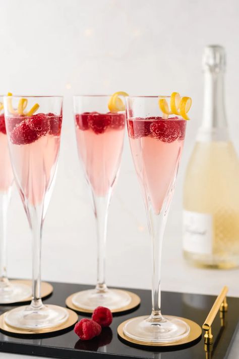 Tart, sweet, and with a bit of a kick, this French Kiss Cocktail is THE perfect cocktail to serve at a celebration. This raspberry and lemon sparking drink is simple to make and so delicious. Cute Birthday Cocktails, French Kiss Drink, French Cocktail Party, Raspberry Themed Party, French Drinks Cocktails, French Cocktails Recipes, French Bachelorette Party, French Kiss Cocktail Recipe, French Party Food