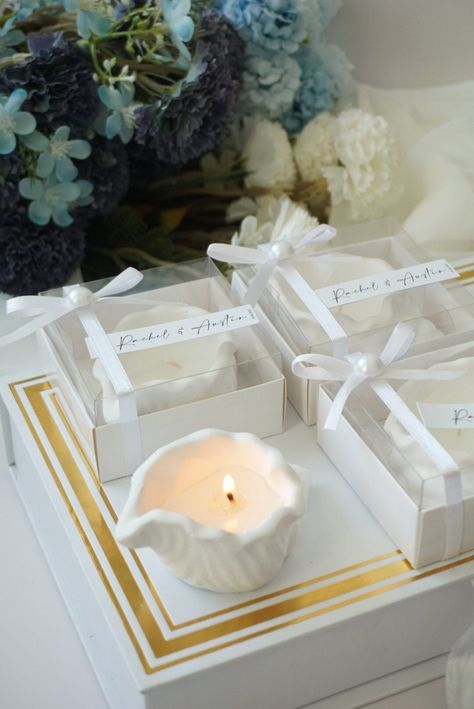 Celebrate your special occasions with our Elegant Custom Seashell Handmade candle. This unique candle, carefully crafted in the shape of an oyster shell, serves as a beautiful decoration and a welcome gift for your guests. Perfect for weddings, engagements, baby showers, bridal showers or christenings, these shell-shaped candles add elegance and charm to any event. They create a calm and romantic atmosphere with a soft, relaxing glow, creating the perfect mood for your celebrations. Product Size: Candle Size: 9x9x4 cm ( 3.54 x 3.54 x 1.57 inches) Box Size: 8x8x4 cm ( 3.14 x 3.14 x 1.57 inches ) Wedding Favors Beach Theme, Elegant Beach Wedding Decorations, Bridal Shower Gifts For Guests, Sea Shell Candle, Beach Bridal Shower Favors, Beach Theme Candles, Beach Theme Wedding Favors, Ocean Wedding Theme, Beach Party Favors