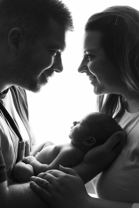 black and white image of Mum and Dad holding newborn baby girl and smiling at eachother First Time Family Photos, New Born Parents Pictures, Couples Newborn Photoshoot, Baby Photo Shoot With Parents, Family Portrait Newborn, Baby Photo With Parents, Black And White Newborn Family Pictures, Studio Newborn Parent Poses, Black And White Newborn Photos