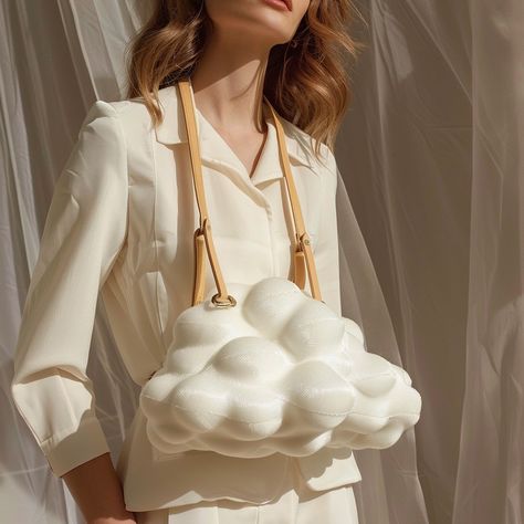 The cloud-shaped handbag is a whimsical accessory that adds a touch of dreaminess to any outfit. Crafted from soft, high-quality materials, this handbag mimics the fluffy, ethereal look of a cloud. Its gentle curves and smooth texture create an inviting, playful silhouette. The bag features a spacious interior with secure compartments, making it both stylish and practical. With its charming design and impeccable craftsmanship, the cloud-shaped handbag is perfect for those who love to make a f... Whimsical Accessories, Cloud Bag, Smooth Texture, Fashion Statement, Texture, Handbags, High Quality, Quick Saves, Design