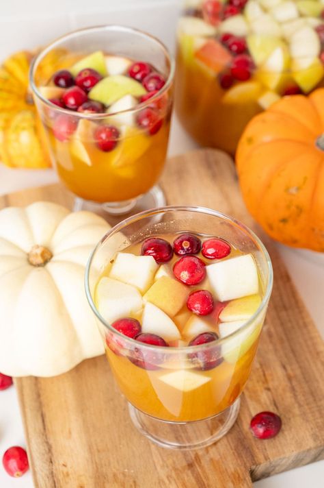 Thanksgiving sangria is a delicious twist on the classic sangria. Think white wine sangria with a fall twist - it has real pumpkin puree, pumpkin pie spice, maple syrup, and fall fruit. It is so good - slightly sweet, perfectly spiced, so quick and easy to make. Definitely a crowd-pleaser! Thanksgiving Sangria, Real Pumpkin Puree, Puree Pumpkin, White Wine Sangria, Pumpkin Syrup, Rose Sangria, Fall Fruit, Wine Sangria, Homemade Apple Cider