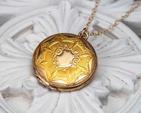 A vintage locket necklace with a glimpse into places that feel both familiar and dreamlike. This vintage locket necklace is a timeless piece carrying two hand-painted memoryscape oil paintings, each rendered in warm sepia tones. Strung on a long gold-filled chain, this gold-toned locket showcases an intricately engraved front that’s as captivating as it is unique. Each delicate oil painting depicts serene fields offering a glimpse into places that feel both familiar and dreamlike. DETAILS: One-of-a-kind 2 original mini paintings: oil on linen, approx. 3/4" Vintage gold-toned locket Locket is 1-1/16 inch in diameter Approx. 5.5mm thick Gold-filled chain, 28.5" long Ready to ship—please allow 1 week for processing Locket Necklace Vintage, Vintage Lockets, Mini Paintings, Locket Necklace, Gold Filled Chain, Vintage Gold, Locket, Timeless Pieces, Oil Painting