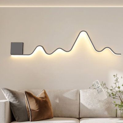 The wall sconce lighting fixture designed in a unique wavy and linear structure shape, add more fashion elements to your house, blends with most types of home decoration style. This modern wall sconces have a memory function. When you turn it on, it will maintain the lighting mode you turned off last time. And its light color and brightness can be adjusted. | Wrought Studio™ Heidamos 1 - Light 43.3" Aluminum LED Flush Mounted Sconce Metal in Black / White | 7.08 H x 43.3 W in | Wayfair Modern Ambient Lighting, Wall Lights Behind Sofa, Wall Art Lighting Ideas, Dining Room Wall Lighting, Creative Bedroom Lighting, Lights Behind Couch, Neon Sign Living Room Decor, Pictures With Lights On Wall, Hallway Wall Decor Modern