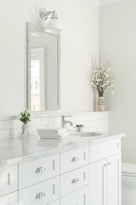 Chic, white bathroom features a white washstand adorned with polished nickel vintage cup pulls topped with white marble fitted with a round sink and modern faucet accented with a subway tiled backsplash with a marble ledge placed under a mirror tile mirror. Vanity Backsplash, Bathroom Tile Inspiration, Modern Bathroom Tile, Small Bathroom Vanities, Marble Backsplash, White Vanity Bathroom, Bathroom Backsplash, Trendy Bathroom, Upstairs Bathrooms