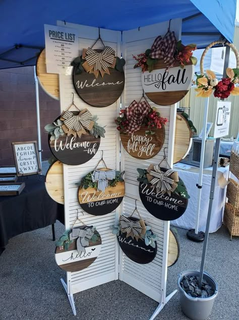 Hanging Sign Display Craft Fairs, Sign Display For Craft Show, Holiday Market Vendor Booth Ideas, Porch Leaner Display Craft Show, Craft Booth Wall Ideas, Christmas Vendor Fair Ideas, How To Display Door Signs At Craft Show, Wreath Craft Fair Display, Outside Business Decor