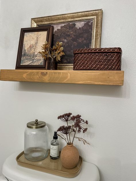 Women’s Bathroom Organization, Floating Wall Shelf Decor, How To Decorate Above Toilet, Over Toilet Shelf Decor, Bathroom Decor Cottagecore, Toilet Top Decor Ideas, Vintage Apartment Bathroom, Master Bath Counter Decor, Thrifted Bathroom Decor