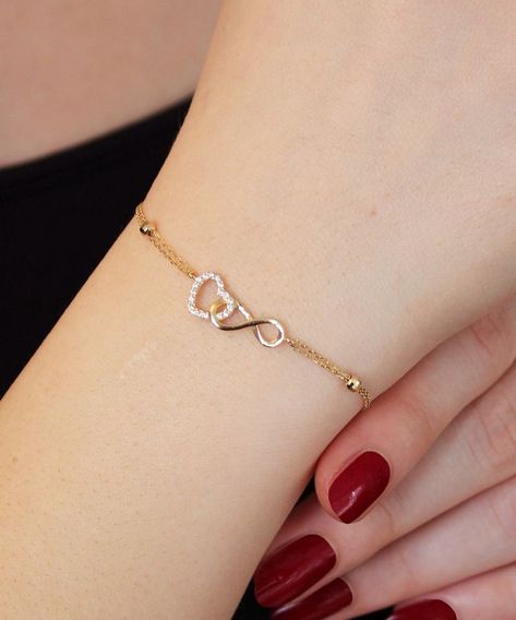 14K Gold Heart and Infinity Symbol Bracelet A symbol of infinite love, this elegant bangle bracelet showcases the symbols of love and eternity entwined with each other. The heart motif perfectly complements the infinity symbol for a truly romantic look. This unique bracelet is perfect for everyday wear as it is made of solid gold and won't tarnish. It is a wonderful gift for a special person. Features: * This bracelet is made of patented 14K solid gold. * It has a 16cm chain and 2cm charm Gold Unique Bracelet For Women, Hand Wear Accessories, Gold Heart Bracelet For Women, Heart And Infinity Necklace, Fashion And Accessories, Women’s Bracelets Gold, A Bracelet Gold, Simple Hand Bracelet, Bracelet Design For Girls In Gold